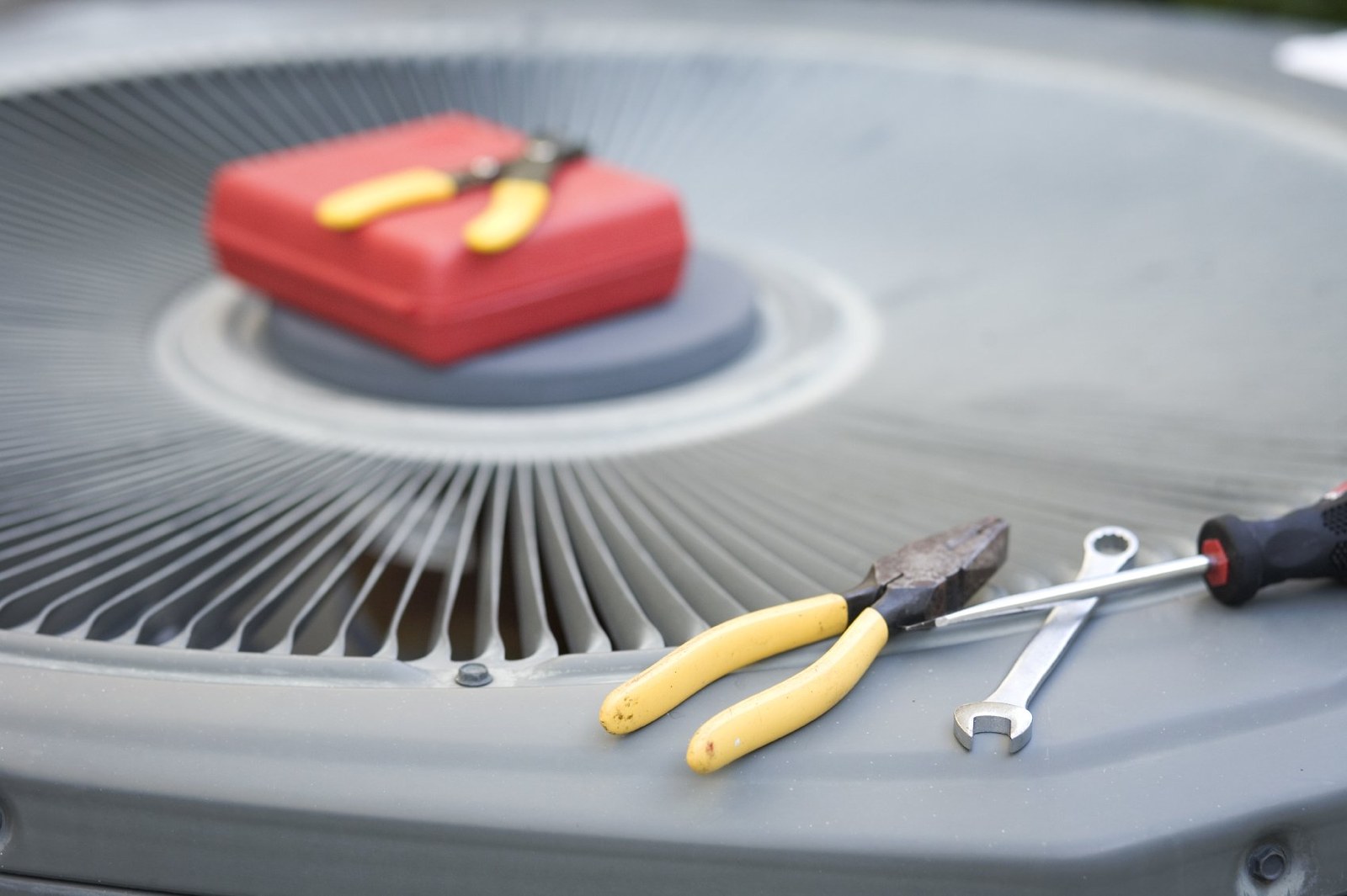 Tools laid out on top of an outdoor condenser during a service visit